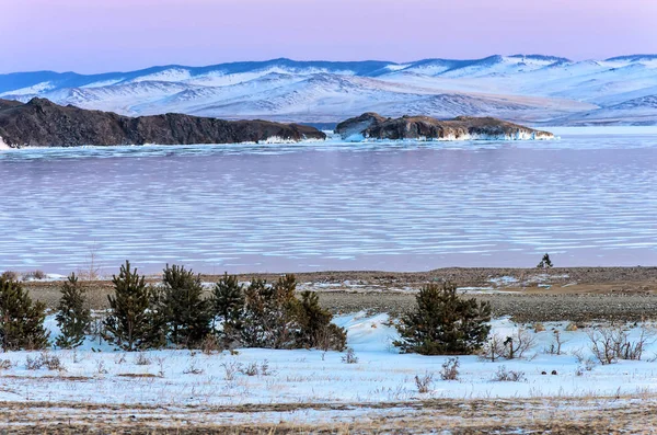 在贝加尔湖的夕阳下, 有美丽的冬冻湖和雪山。全景 — 图库照片