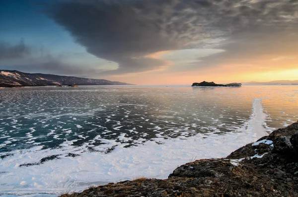 Lago Baikal congelado. Lindas nuvens de estratos sobre a superfície do gelo em um dia gelado . — Fotografia de Stock