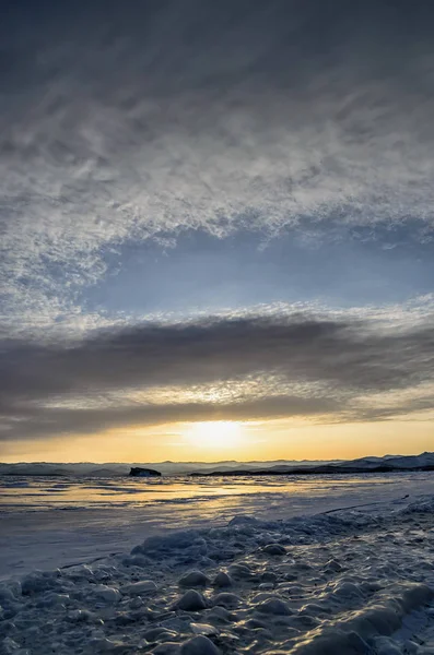 Lago Baikal congelado. Lindas nuvens de estratos sobre a superfície do gelo em um dia gelado . — Fotografia de Stock