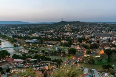 Georgia, Tiflis - Temmuz, 4, 2018. Kura Nehri ve Tiflis eski şehir. Gürcistan'da yaz saati görünümünde günbatımı