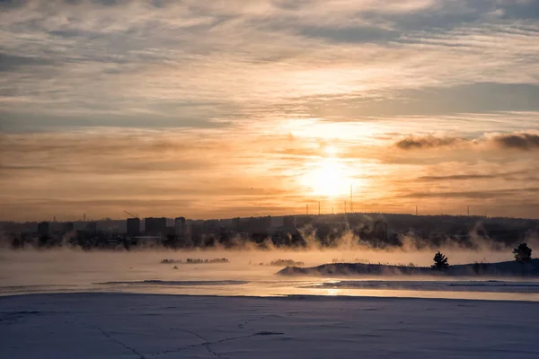 Winter Angara. The city embankment of the Angara River on a Sunday sunny winter day with fog. Winter Irkutsk