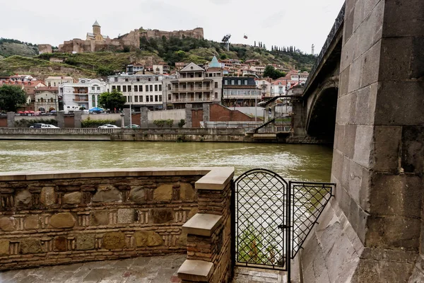 Tiflis, Georgia - 5 de julio de 2018. Mazmorra de la iglesia Virgen María Metekhi y el río Kura — Foto de Stock
