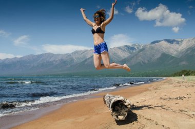 Çok eski çürümüş ahşap kız atlama karaya plaja yakın Deniz Baykal, Rusya, yaz aylarında güneşli bir oturum