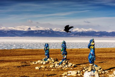 Sacred place with obo. Winter landscape of Mongolia. Lake Khubsugul and mountain clipart