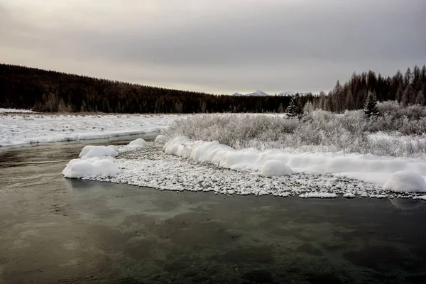 Paysage hivernal au bord d'une rivière au coucher du soleil — Photo