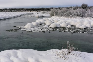 Gün batımında nehir kıyısında kış manzarası