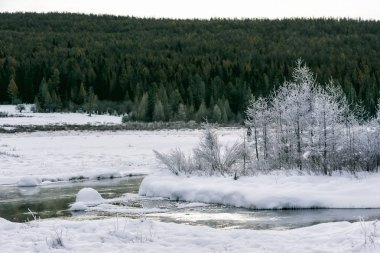 Gün batımında nehir kıyısında kış manzarası