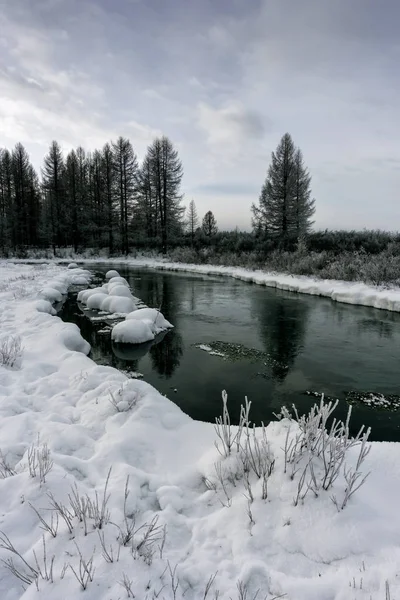 Paisagem de inverno por um rio ao pôr do sol — Fotografia de Stock