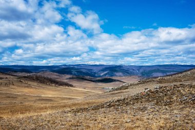 Beyaz bulutlar Tazheran bozkır, Sibirya Rusya ile mavi gökyüzü altında sarı çim ile geniş bozkır