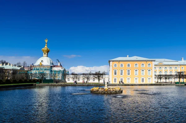 PETERHOF, ST. PETERSBURG, RUSIA - 4 DE MAYO DE 2015: Capilla Este flanqueando los edificios centrales del Palacio de Gran Peterhof con reflexión — Foto de Stock
