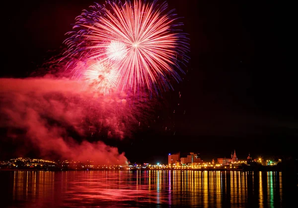 uzun pozlama üzerinde sakin su dalgalanan yansıtan havai fişek