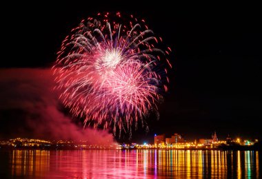 uzun pozlama üzerinde sakin su dalgalanan yansıtan havai fişek