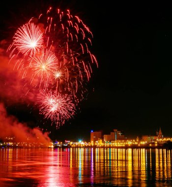 uzun pozlama üzerinde sakin su dalgalanan yansıtan havai fişek