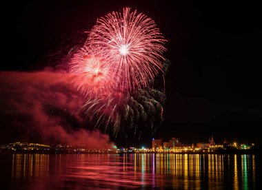 uzun pozlama üzerinde sakin su dalgalanan yansıtan havai fişek