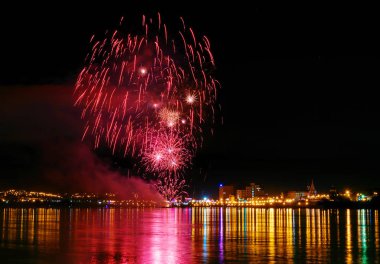 uzun pozlama üzerinde sakin su dalgalanan yansıtan havai fişek