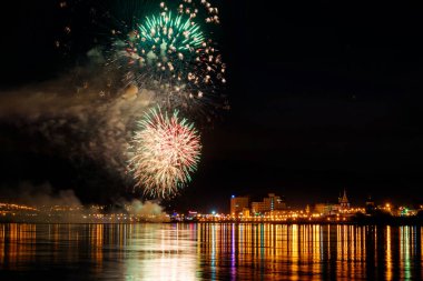 uzun pozlama üzerinde sakin su dalgalanan yansıtan havai fişek