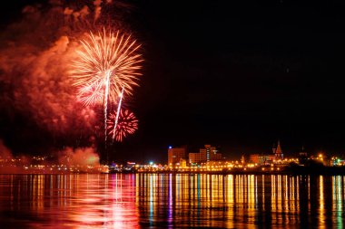uzun pozlama üzerinde sakin su dalgalanan yansıtan havai fişek