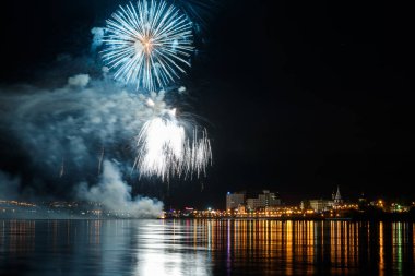 uzun pozlama üzerinde sakin su dalgalanan yansıtan havai fişek