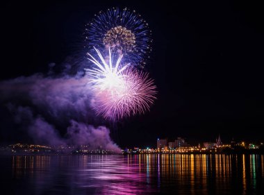 uzun pozlama üzerinde sakin su dalgalanan yansıtan havai fişek