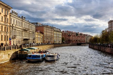 Saint Petersburg, Rusya, 4 Mayıs 2019 - öğleden sonra evlerin renkli cepheleri ile nehir dolgu yakınındaki sokak