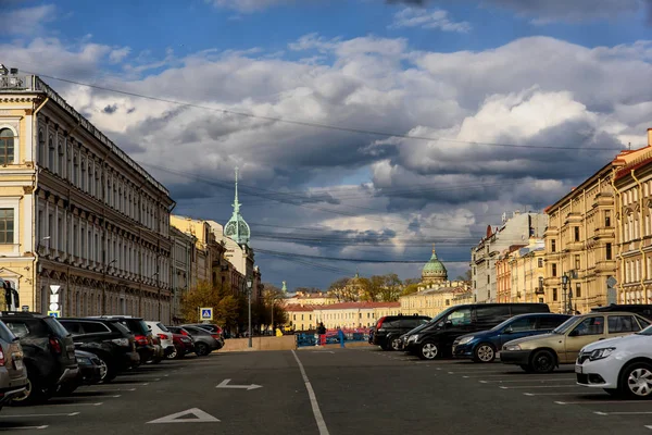 Petrohrad, Rusko-Květen 4, 2019: pohled na ulici s parkovacími vozy za jarního slunného dne s tmavě oblačnou oblohou — Stock fotografie