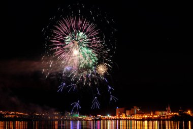 uzun pozlama üzerinde sakin su dalgalanan yansıtan havai fişek