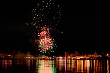 uzun pozlama üzerinde sakin su dalgalanan yansıtan havai fişek