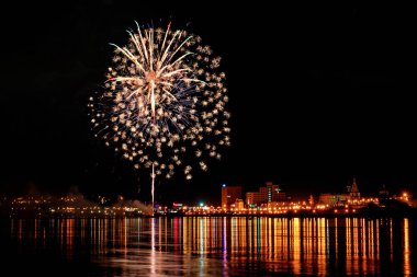 uzun pozlama üzerinde sakin su dalgalanan yansıtan havai fişek