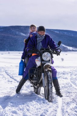 Khanh, Moğolistan, Şubat, 25, 2018. Kışın iki kişi motosiklet sürüyor