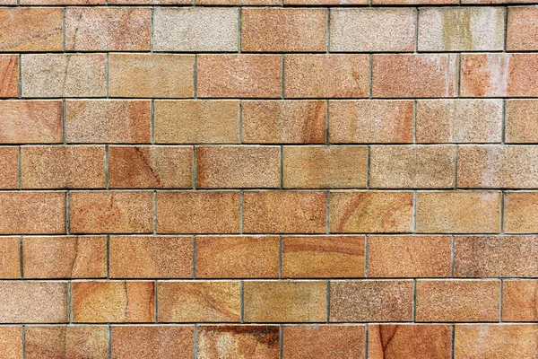 Old orange brick wall, texture of orange stone blocks closeup. Wall texture