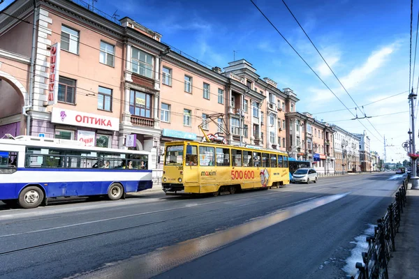Irkutsk, Rusko, červenec, 6, 2019. Tramvaj a autobus s reklamou procházející Leninovou ulicí — Stock fotografie