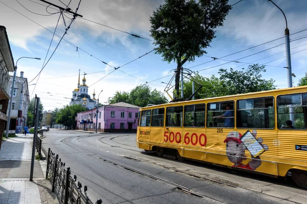 Irkutsk, Rusia, 6 de julio de 2019. Tranvía con publicidad pasando cerca de Harlampievskaya Michael la Iglesia Arcángel — Foto de Stock