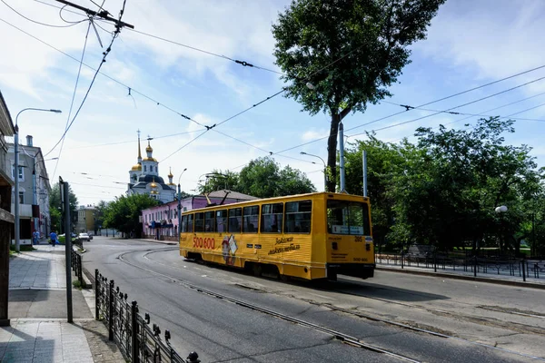 Іркутськ, Росія, 6 липня 2019 р. Трамвай з рекламою, що проходить біля Харламевська Михаїла Архангельський костел — стокове фото