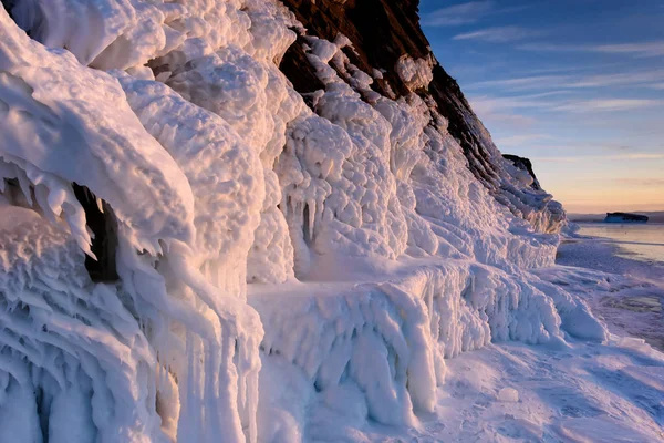 Lago Baikal está cubierto de hielo y nieve, fuerte frío, hielo azul claro grueso. Icicles cuelgan de las rocas. El lago Baikal es un día helado de invierno. Increíble lugar —  Fotos de Stock