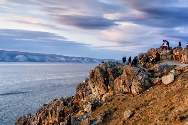 Región de Irkutsk, Rusia - 16 de septiembre de 2017: La gente ve una hermosa puesta de sol en espectaculares rocas en la isla de Olkhon Shamanka, popular destino de viaje en el lago Baikal — Foto de Stock