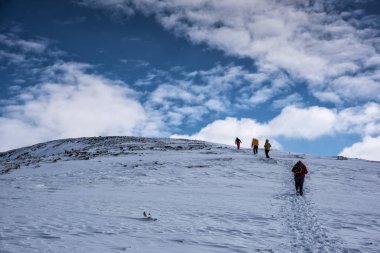 Irkutsk bölgesi, Rusya, Slyudyanka - 13 Nisan 2019: Bir grup insan dağda yürüyüş yapıyor ve köknar ağaçlarının arasında kar da görülüyor