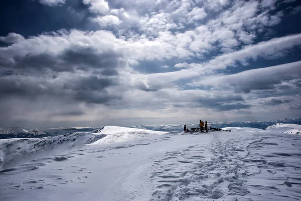 Irkutsk region, Rusya, Slyudyanka - 13 Nisan 2019: Bir grup insan dağda ve karda bulutlu gökyüzüile kalıyor — Stok fotoğraf