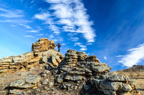 Región de Irkutsk, Rusia, Sakhurta - 19 de octubre de 2013: El hombre permanece en la roca en la estepa de Tazhenranskaya en la costa oeste del lago Baikal, Siberia — Foto de Stock