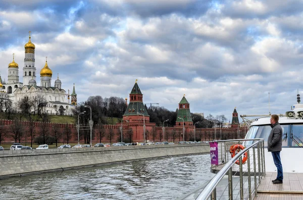 Moskwa, Rosja - 11 marca 2014: Człowiek patrzy na Wielki Pałac Kremlowy, a Iwan Wielki Dzwon na statek nad rzeką Moskwą — Zdjęcie stockowe
