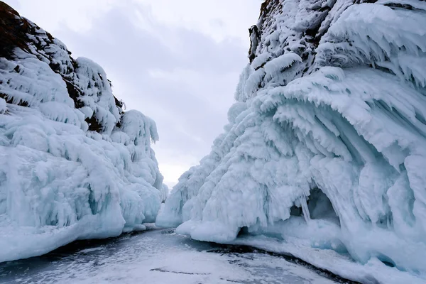Dwie skały pokryte soplami lodu. Jezioro Baikal w pochmurną pogodę. Południowy Przylądek wyspy Olkhon — Zdjęcie stockowe