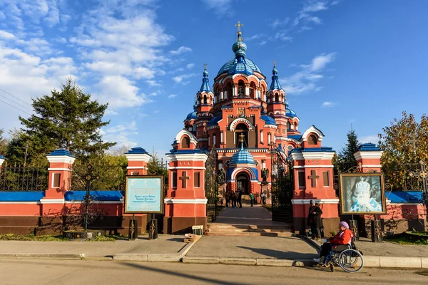 Irkutsk, Rusia - 8 de octubre de 2019: Una mujer en silla de ruedas ruega cerca de la iglesia ortodoxa de la señora de Kazán —  Fotos de Stock