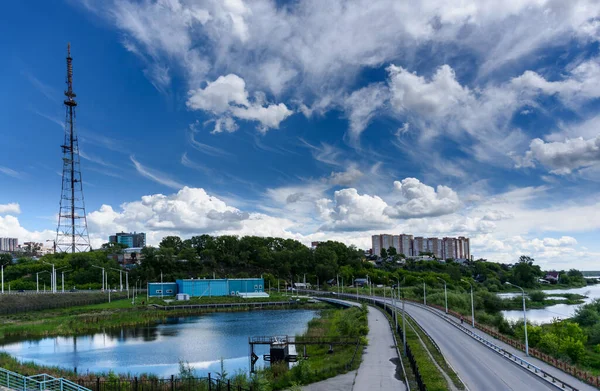 Vue panoramique sur la ville d'Irkoutsk, petit étang avec réflexion, tour de télévision et route depuis le pont académique dans la journée ensoleillée d'été avec de beaux nuages — Photo