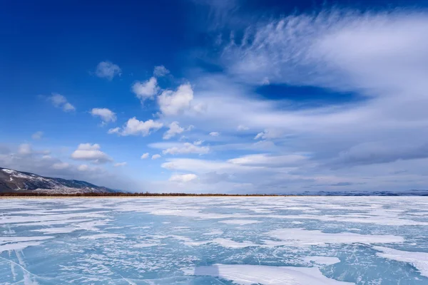 Παγωμένη λίμνη Baikal. Όμορφα σύννεφα στρώμα πάνω από την επιφάνεια του πάγου σε μια παγωμένη ημέρα. — Φωτογραφία Αρχείου