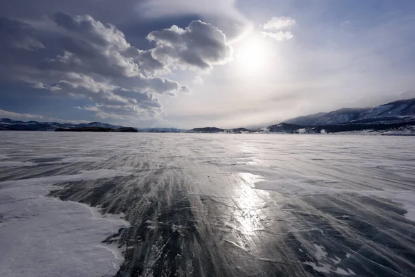 얼음 위로 아름다운 구름이 떠 있고 서리가 내리는 날에는 바람 이 부는 눈이 떠오릅니다. 바이칼호 의얼어붙은 호수. — 스톡 사진