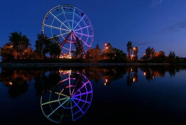 Красочное абстрактное колесо обозрения с отражением на острове Конный в городе Иркутске — стоковое фото
