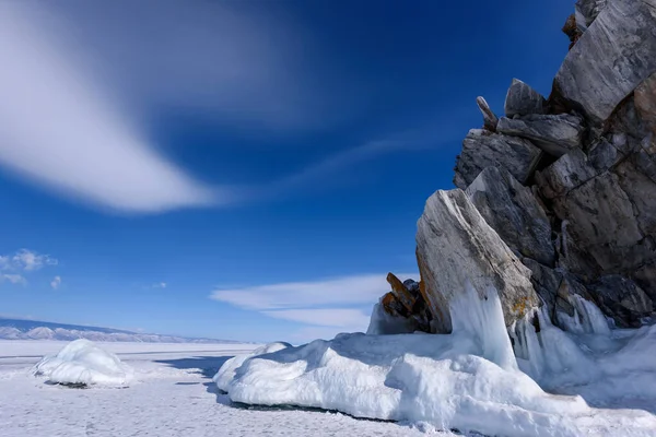 Capo Burhan sulla roccia di Shamanka nell'isola di Olkhon ricoperta di ghiaccioli nella soleggiata giornata di marcia. Lago Baikal con belle nuvole — Foto Stock