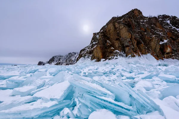Olkhon Adası 'ndaki Cape Hoboy, güneşli yürüyüş gününde buz saçaklarıyla kaplıydı. Bulutlu gökyüzü ve büyük mavi buz bloklarıyla Baykal Gölü