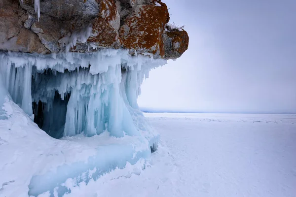 Rock covered with icicles. Lake Baikal in cloudy weather. — Stock Photo, Image