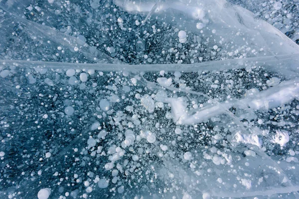 Beautiful ice of Lake Baikal with abstract cracks and frozen air bubbles — Stock Photo, Image