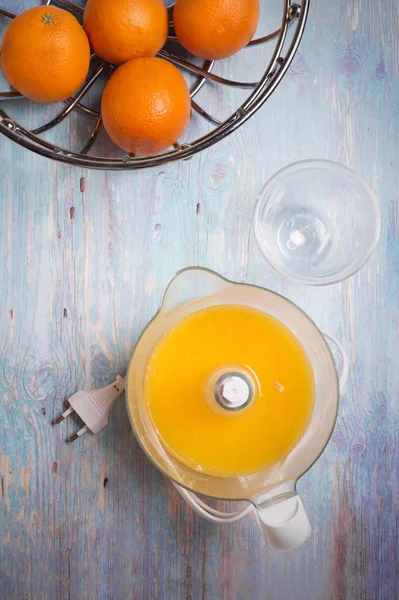 Succo d'arancia fresco con spremiagrumi al tavolo blu — Foto Stock